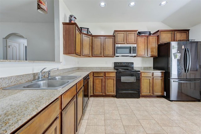 13664 NW Bradbury Ln, Piedmont, OK 73078 - kitchen with black appliances, light countertops, arched walkways, brown cabinets, and recessed lighting