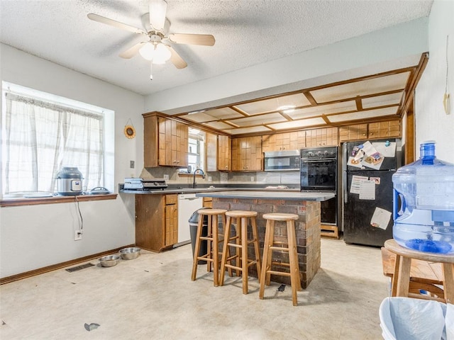 200 S Morgan Dr, Moore, OK 73160 - kitchen featuring freestanding refrigerator, stainless steel microwave, brown cabinets, white dishwasher, and a center island