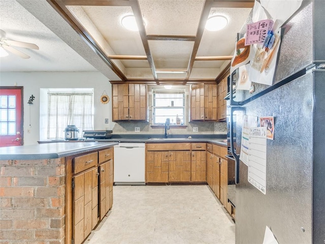 200 S Morgan Dr, Moore, OK 73160 - kitchen with white dishwasher, ceiling fan, brown cabinets, a center island, and a textured ceiling