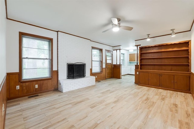 320 E 13th St, Edmond, OK 73034 - unfurnished living room with ceiling fan, a brick fireplace, ornamental molding, a wainscoted wall, and light wood finished floors