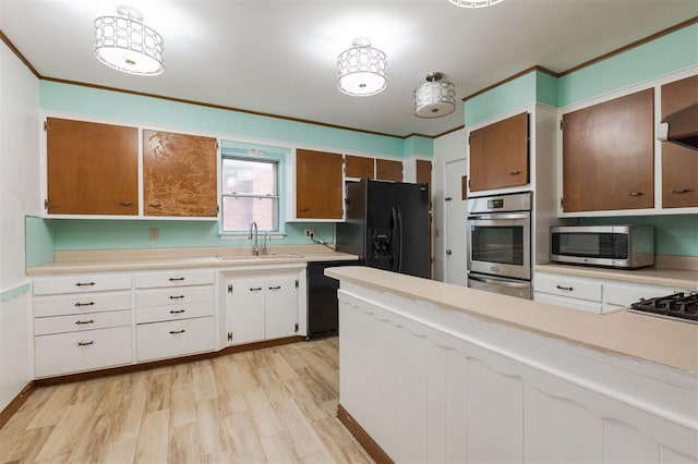 320 E 13th St, Edmond, OK 73034 - kitchen with black appliances, light countertops, light wood-style floors, a warming drawer, and white cabinets