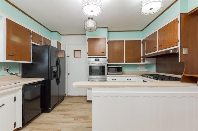 320 E 13th St, Edmond, OK 73034 - kitchen featuring appliances with stainless steel finishes, under cabinet range hood, light wood-style flooring, light countertops, and a peninsula