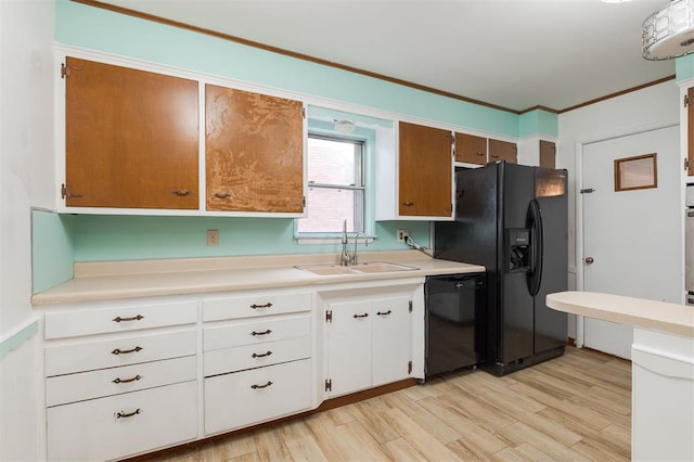320 E 13th St, Edmond, OK 73034 - kitchen featuring black appliances, light countertops, light wood-type flooring, white cabinets, and ornamental molding