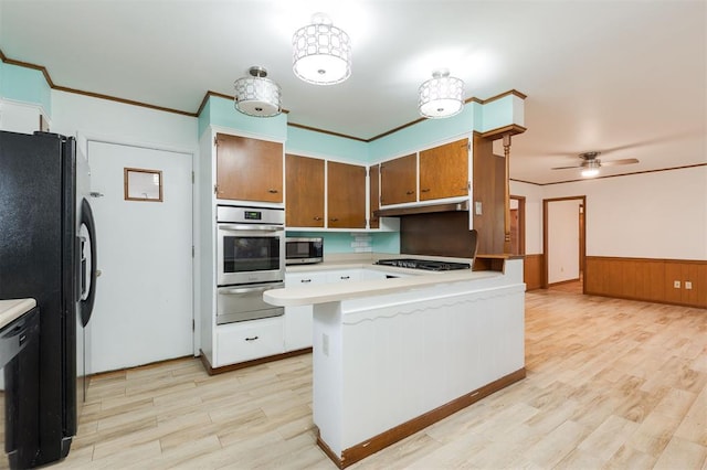 320 E 13th St, Edmond, OK 73034 - kitchen featuring black appliances, a warming drawer, light countertops, a peninsula, and light wood finished floors