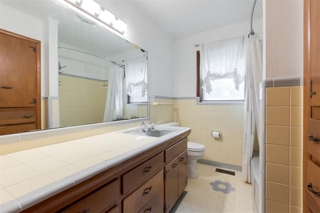 320 E 13th St, Edmond, OK 73034 - full bathroom featuring vanity, tile walls, wainscoting, and shower / bath combination with curtain