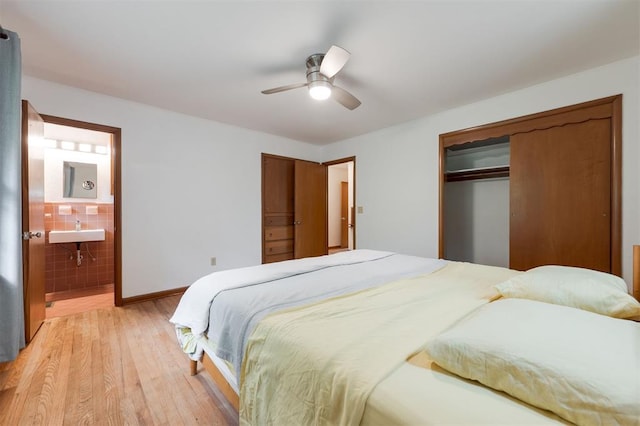 320 E 13th St, Edmond, OK 73034 - bedroom with light wood finished floors, tile walls, ensuite bath, ceiling fan, and a closet