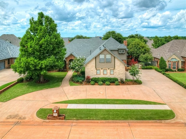 325 NW 146th St, Edmond, OK 73013 - view of front of home featuring concrete driveway, a front yard, stone siding, and a chimney