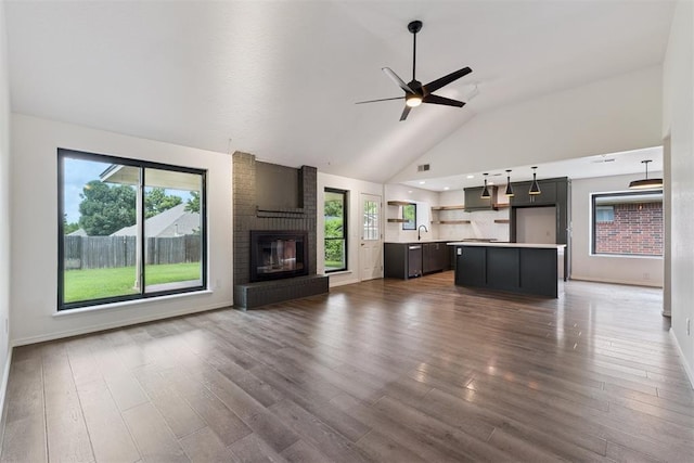 1729 Dena Dr, Edmond, OK 73003 - unfurnished living room with a ceiling fan, a fireplace, wood finished floors, and high vaulted ceiling