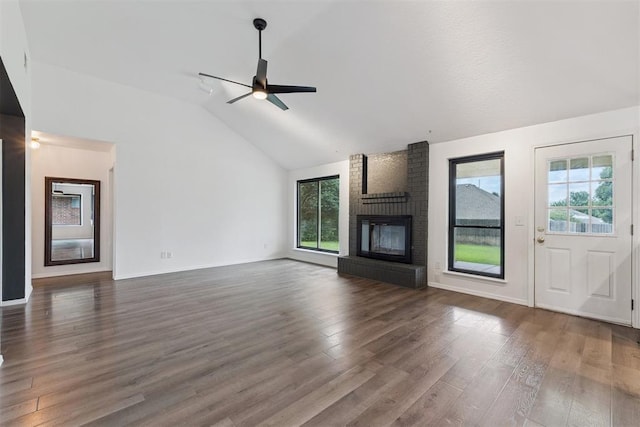 1729 Dena Dr, Edmond, OK 73003 - unfurnished living room with lofted ceiling, plenty of natural light, ceiling fan, dark wood-style flooring, and a fireplace