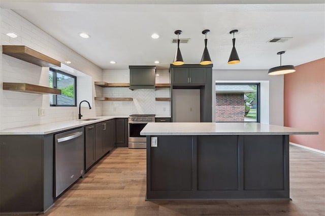1729 Dena Dr, Edmond, OK 73003 - kitchen featuring open shelves, appliances with stainless steel finishes, backsplash, light wood-style flooring, and a center island