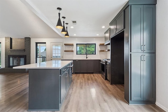 1729 Dena Dr, Edmond, OK 73003 - kitchen with open shelves, stainless steel range with gas stovetop, light wood-type flooring, a center island, and recessed lighting