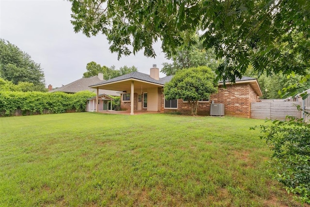 1729 Dena Dr, Edmond, OK 73003 - rear view of house with a patio, brick siding, and a chimney