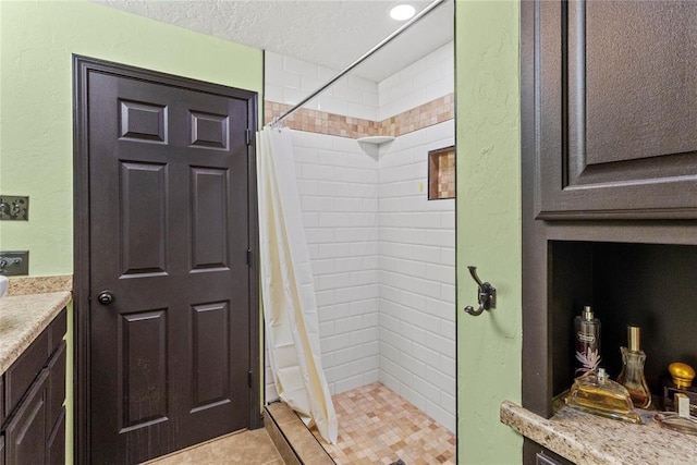 625 N Broadway St, Hydro, OK 73048 - full bath featuring vanity, a shower stall, a textured ceiling, a textured wall, and tile patterned floors