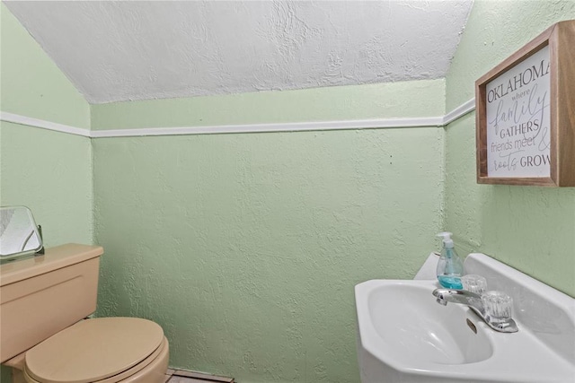 625 N Broadway St, Hydro, OK 73048 - half bath featuring lofted ceiling, a textured wall, and a textured ceiling