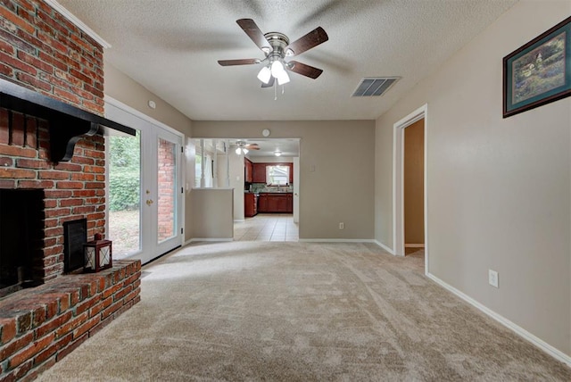 3708 Greenway Ter, Del City, OK 73115 - unfurnished living room featuring a ceiling fan, a textured ceiling, light carpet, and a brick fireplace
