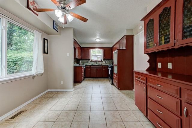 3708 Greenway Ter, Del City, OK 73115 - kitchen with decorative backsplash, ceiling fan, light tile patterned floors, glass insert cabinets, and a textured ceiling
