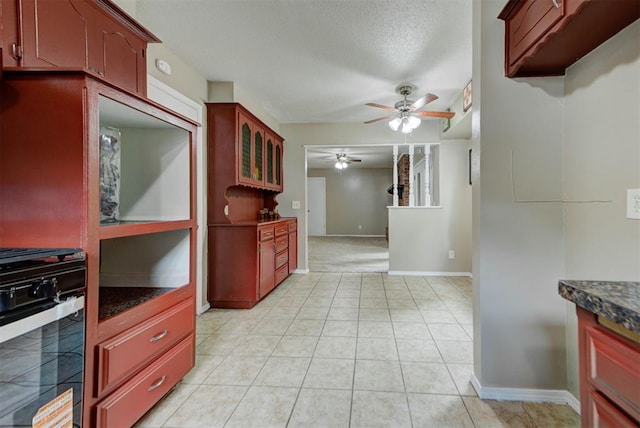 3708 Greenway Ter, Del City, OK 73115 - kitchen featuring black gas range, ceiling fan, dark countertops, a textured ceiling, and light tile patterned floors