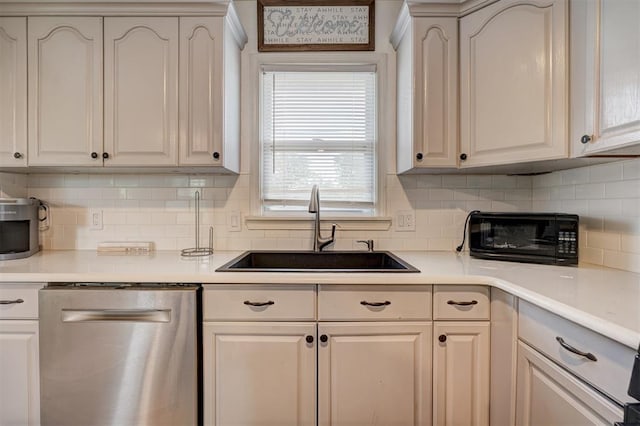1701 Andover Ct, The Village, OK 73120 - kitchen with stainless steel dishwasher, tasteful backsplash, and light countertops