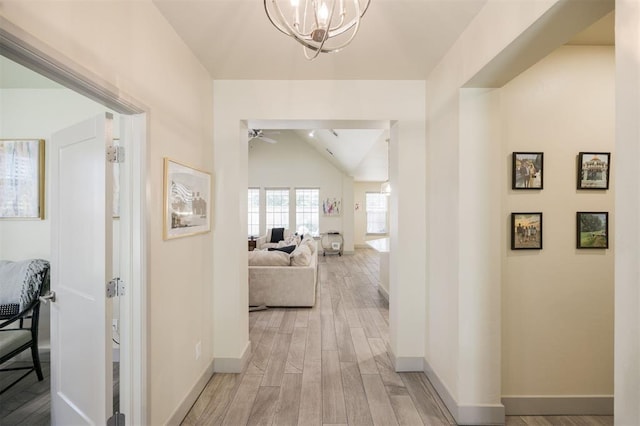 5521 N Miller Ave, Oklahoma City, OK 73112 - hall featuring vaulted ceiling, light wood-type flooring, and a chandelier