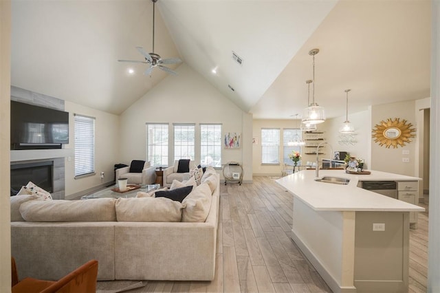 5521 N Miller Ave, Oklahoma City, OK 73112 - living room with light wood-style floors, high vaulted ceiling, ceiling fan, and a fireplace
