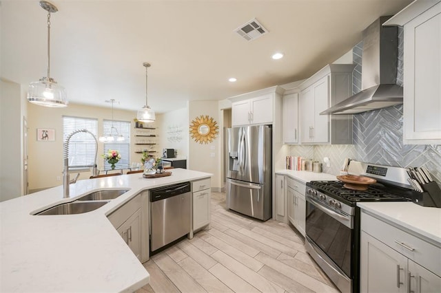 5521 N Miller Ave, Oklahoma City, OK 73112 - kitchen featuring appliances with stainless steel finishes, wall chimney exhaust hood, light countertops, pendant lighting, and backsplash