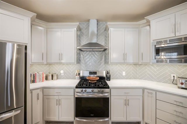 5521 N Miller Ave, Oklahoma City, OK 73112 - kitchen featuring appliances with stainless steel finishes, wall chimney range hood, white cabinets, decorative backsplash, and light countertops