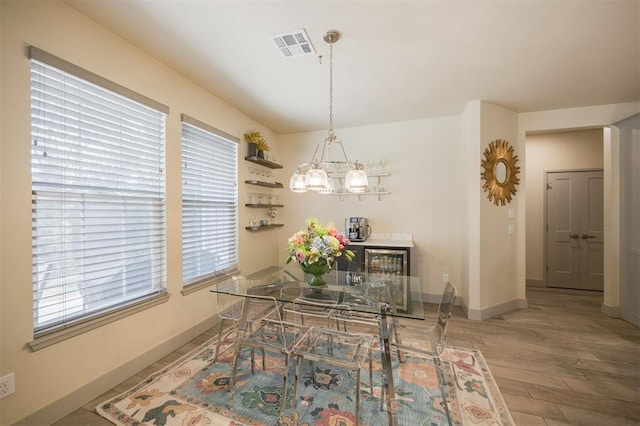 5521 N Miller Ave, Oklahoma City, OK 73112 - dining area with a chandelier, wood finished floors, and wine cooler