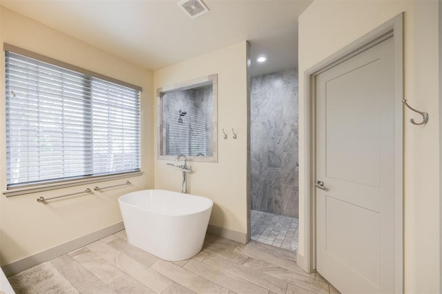 5521 N Miller Ave, Oklahoma City, OK 73112 - bathroom featuring a walk in shower, a freestanding tub, and recessed lighting
