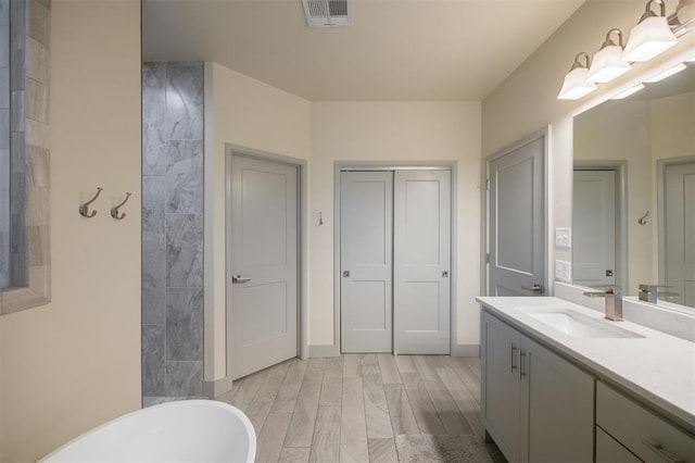 5521 N Miller Ave, Oklahoma City, OK 73112 - full bathroom featuring a soaking tub, vanity, and wood finished floors