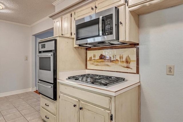 829 Arnold Ave, Moore, OK 73160 - kitchen with appliances with stainless steel finishes, a warming drawer, backsplash, light countertops, and ornamental molding
