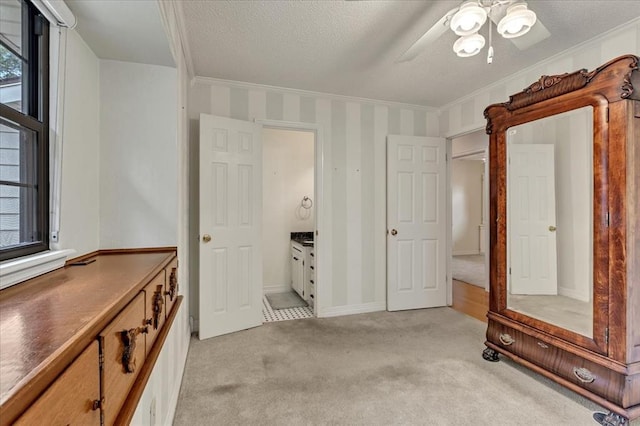 829 Arnold Ave, Moore, OK 73160 - unfurnished bedroom with light colored carpet, a textured ceiling, ornamental molding, and a ceiling fan