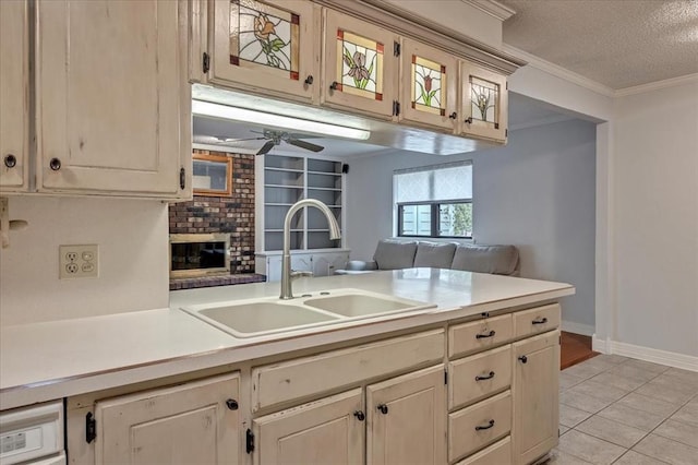 829 Arnold Ave, Moore, OK 73160 - kitchen with a textured ceiling, light countertops, ceiling fan, light tile patterned floors, and ornamental molding