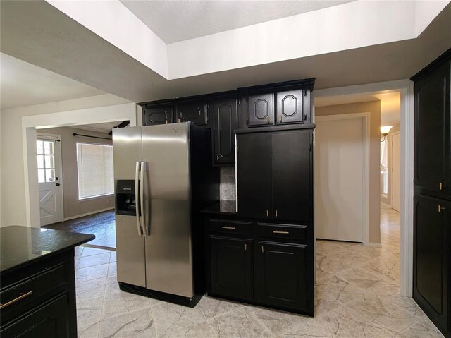 11208 NW 113th St, Yukon, OK 73099 - kitchen with stainless steel fridge with ice dispenser, dark countertops, dark cabinetry, and light marble finish floors