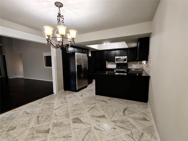 11208 NW 113th St, Yukon, OK 73099 - kitchen featuring stainless steel appliances, tasteful backsplash, a chandelier, dark countertops, and dark cabinetry