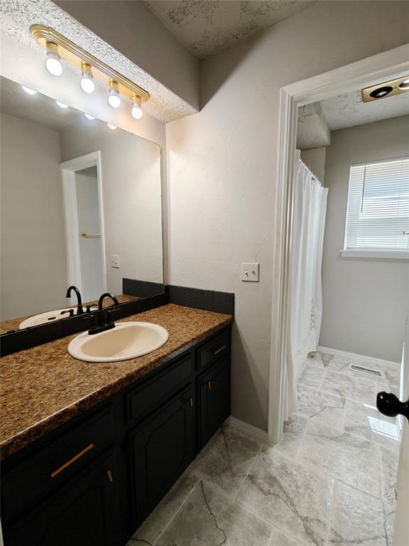 11208 NW 113th St, Yukon, OK 73099 - full bathroom with vanity and baseboards