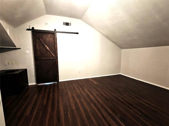 11208 NW 113th St, Yukon, OK 73099 - additional living space featuring wood finished floors, a barn door, and lofted ceiling