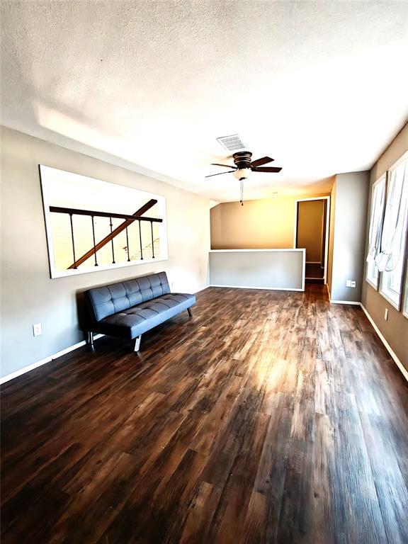 11208 NW 113th St, Yukon, OK 73099 - unfurnished room featuring wood finished floors, ceiling fan, and a textured ceiling