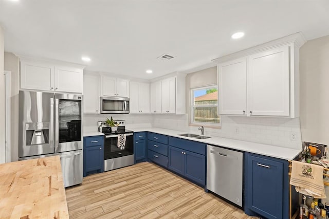 104 N Ramblin Oaks Dr, Moore, OK 73160 - kitchen featuring stainless steel appliances, blue cabinets, white cabinets, tasteful backsplash, and recessed lighting