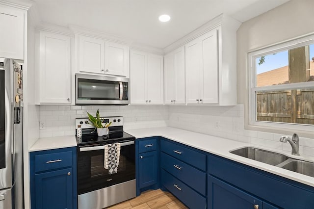 104 N Ramblin Oaks Dr, Moore, OK 73160 - kitchen featuring stainless steel appliances, blue cabinets, white cabinets, light countertops, and recessed lighting