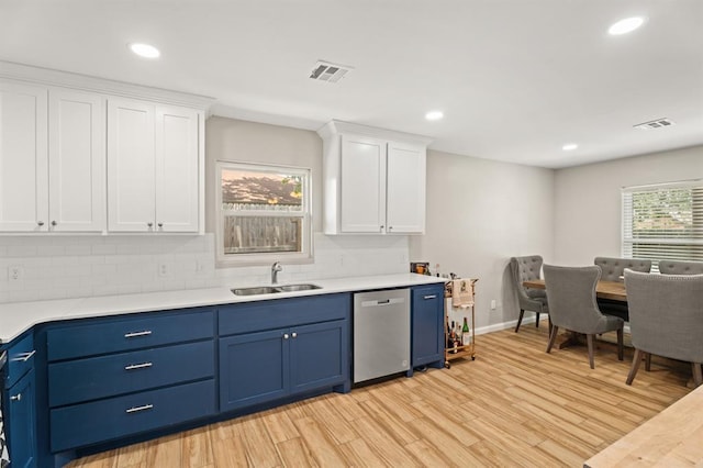 104 N Ramblin Oaks Dr, Moore, OK 73160 - kitchen with stainless steel dishwasher, blue cabinetry, white cabinetry, light wood finished floors, and recessed lighting