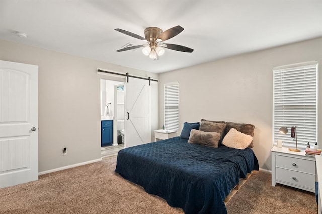 104 N Ramblin Oaks Dr, Moore, OK 73160 - carpeted bedroom featuring a barn door, ensuite bath, and a ceiling fan