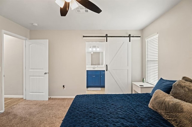 104 N Ramblin Oaks Dr, Moore, OK 73160 - bedroom featuring a barn door, light colored carpet, ensuite bathroom, and ceiling fan