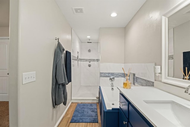 104 N Ramblin Oaks Dr, Moore, OK 73160 - bathroom featuring double vanity, tiled shower, wood finished floors, a bathtub, and recessed lighting