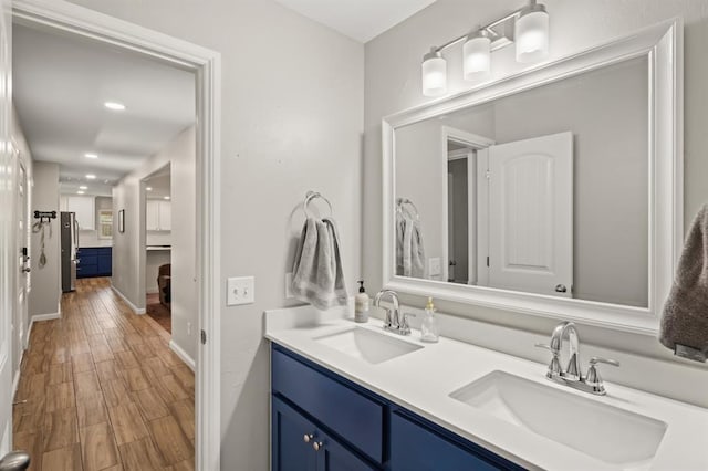 104 N Ramblin Oaks Dr, Moore, OK 73160 - bathroom featuring double vanity, wood finished floors, and recessed lighting