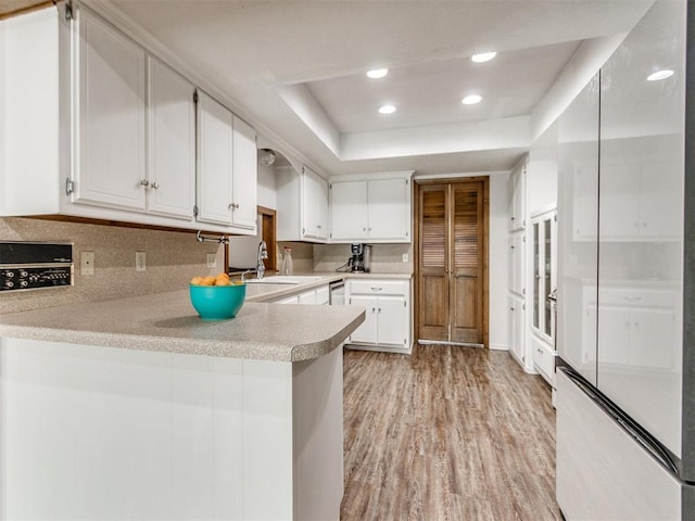 6708 Basswood Canyon Rd, Oklahoma City, OK 73162 - kitchen with light wood finished floors, a peninsula, light countertops, recessed lighting, and white cabinetry