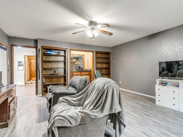 6708 Basswood Canyon Rd, Oklahoma City, OK 73162 - living room with a ceiling fan, light wood-style flooring, built in features, and a textured ceiling
