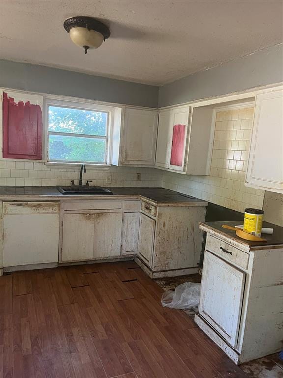 505 S Jackson Ave, Blanchard, OK 73010 - kitchen with white dishwasher, backsplash, dark wood-style floors, white cabinetry, and dark countertops
