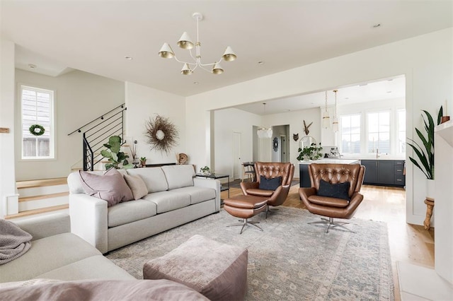 1900 Runway Blvd, Oklahoma City, OK 73108 - living room with a chandelier, stairs, plenty of natural light, and light wood-style flooring