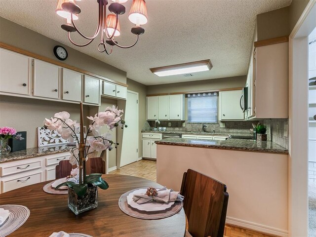 1221 Val Genes Rd, Edmond, OK 73003 - dining area with a textured ceiling, a chandelier, and light wood finished floors