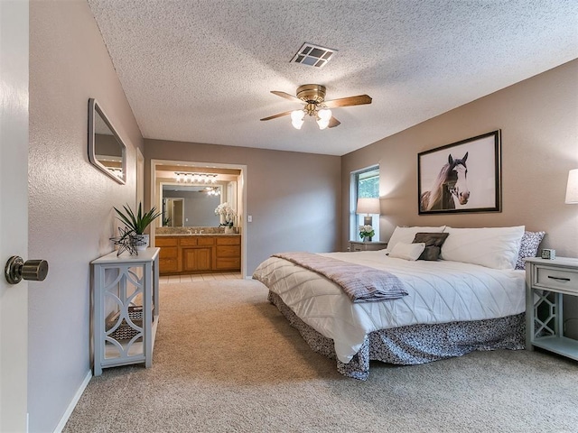 1221 Val Genes Rd, Edmond, OK 73003 - bedroom featuring light colored carpet, a textured ceiling, ceiling fan, and ensuite bath
